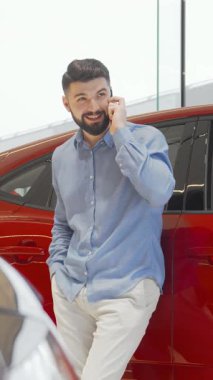 Büyüleyici bir gülümsemesi olan şık bir adam, parlak, modern bir bayilikte parlak, cilalı araçlarla çevrili, hareketli bir telefon konuşmasına dalıyor. Hayalindeki arabayı seçme heyecanıyla eğlenirken coşkusu parlıyor, başarıyı somutlaştırıyor.