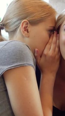 Sıcak bir kafede, iki genç kadın hoş bir dedikodu seansına dalmış, bir kız şakayla birbirlerine bir sır fısıldıyor. Işıl ışıl gülümsemeleri ve hareketleriyle sıcak, davetkar bir atmosfer yaratırlar. Kutlamak için mükemmel bir ortam.