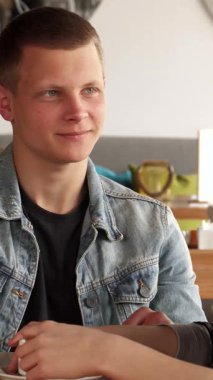 Neşeli bir sarışın adam ve şık kıvırcık saçlı bir kız şık bir kafede kahve içerken kahkaha ve hikayeler paylaşıyorlar. Modern dekor ve yumuşak ışıklandırmayla süslenmiş davetkar ortam, keyifli bir ilişki içinde olduklarında neşeli bağlantılarını güçlendiriyor.