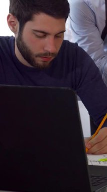 Üç Kafkasyalı mimar, canlı planlar ve proje belgeleriyle çevrili, parlak bir çalışma masasında tutkuyla beyin fırtınası yapıyorlar. Üzerinde beyaz gömlek ve pantolon askısı olan odaklanmış esmer sakallı bir adam eğilir ve nişanlısına yol gösterir.