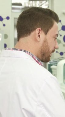 Canlı renklerle dolu şık, modern bir laboratuvarda, iki genç erkek meslektaşı son bilimsel bulgularını tutkuyla tartışıyor. Biri, gevrek bir laboratuvar önlüğü ve lateks eldivenler içinde renkli test tüpleriyle dolu duruyor.