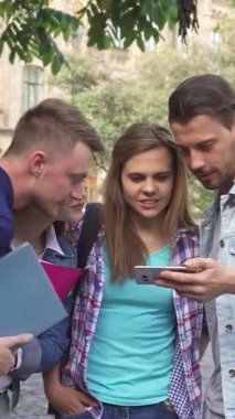 Dört genç öğrenciden oluşan dinamik bir grup, iki erkek ve iki kadın, canlı bir kampüs ortamının ortasındaki akıllı telefon ekranı tarafından büyülenmiş bir şekilde birbirlerine sokuluyorlar. Yakışıklı esmer adam ilginç bir keşfi paylaşırken çekici kızıl saçlı ve...