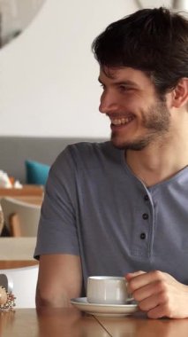 Açık sakallı, çekici Asyalı arkadaşıyla güzel bir kafede keyifli bir sohbeti paylaşan beyaz bir adam, her ikisi de dumanı tüten bir kahve fincanı. Işıl ışıl gülüşleri ve rahat titreşimleri dostluk için mükemmel, rahat bir atmosfer yaratıyor.