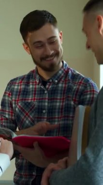 Şık sakallı, esmer, neşeli, beyaz bir erkek öğrenci not defterine bakıp sınıf arkadaşları arasında kahkahalar atıyor. Canlı konferans salonu enerji ile uğulduyor güzel bir kızıl saçlı ve gri elbiseli çekici bir adam olarak.