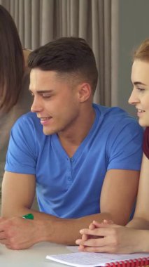 Canlı mavi tişörtlü neşeli esmer bir adam kahkahaya boğuluyor, odayı bulaşıcı enerjiyle aydınlatan komik bir şakayı paylaşıyor. Nişanlı iş arkadaşlarıyla çevrili, gözlüklü beyaz bir kadın dahil, dinamik bir şey yaratıyorlar.