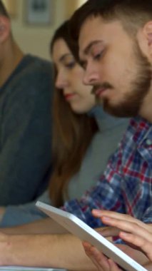 Kendinden emin beyaz bir kadın, canlı bir konferans salonunda odaklanmış sınıf arkadaşları tarafından çevrelenmiş tabletiyle meşgul oluyor. Esmer saçı kameraya döndüğünde yüzünü çerçeveliyor. Akranları özenle not alıyor ve enerjik bir akademik kurum yaratıyor.