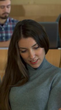 Canlı bir üniversite atmosferinde, üç farklı kız öğrenci resimli bir dergi tarafından büyülenmiş bir animasyon tartışmasını paylaşıyor. Çekici kızıl renkli resimlere heyecanlı bir şekilde işaret ederken, şık sınıf arkadaşları gündelik şıklıkta giyinmiş.