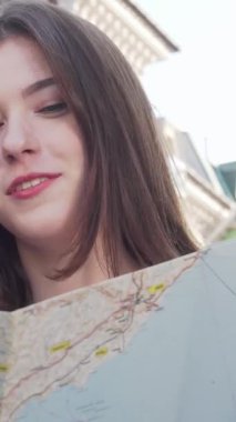 Canlı bir şehir ortamında, biri kıvırcık saçlı, diğeri düz bukleli iki genç kadın, ayrıntılı bir haritayı hevesle inceliyor, yüzleri merak ve heyecanla aydınlanıyor. Bu büyüleyici an dostluğun özünü yakalar ve...