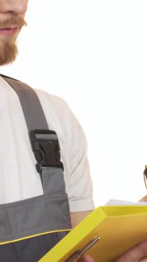 Parlak gri üniformalı, gülümseyen sakallı bir adam coşkuyla parlak sarı bir panoya notlar yazarak profesyonellik ve güven saçıyor. Sıcak ifadesi ve odaklanmış duruşu, inşaata olan bağlılığını ve uzmanlığını vurguluyor.