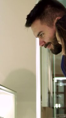 Zarif bir butikte ışıl ışıl parlayan mücevherlerle büyülenmiş şık bir beyaz çift yakına geliyor. Sakallı adam ve sofistike kız arkadaşı zarif yüzükler, küpeler ve kolyeler keşfederken birbirlerine neşeli gülümsediler.