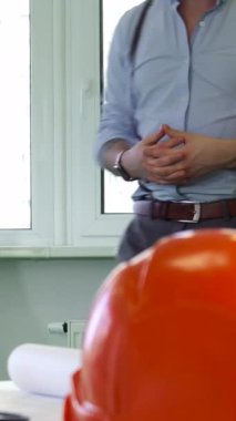 Bu canlı sahnede, iki erkek mimar karmaşık bir masada, planlar ve gerekli aletlerle çevrili bir beyin fırtınası oturumuna tutkulu bir şekilde giriştiler. Sıcak doğal ışık çalışma alanını sarıyor ve odaklanmış ifadelerini aydınlatıyor.