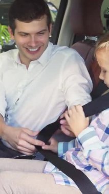 Sıcak ve davetkar bir arabanın içinde şefkatli bir baba kızının emniyet kemerini takar ve onun güvenliğini nazik bir gülümsemeyle sağlar. Neşeli etkileşimleri sevgi ve güven yayar, sıcaklıkla dolu değerli bir aile anını yakalar.