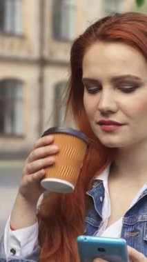 Uçan kızıl saçlı hoş, beyaz bir kız öğrenci akıllı telefonuyla mesajlaşırken şık bir fincandan kahvesinin tadını çıkarıyor. Çekici bir kampüs zeminine, ışıl ışıl gülüşüne ve odaklanmış bakışlarına rağmen öğrencinin coşkulu ruhunu somutlaştırıyor.