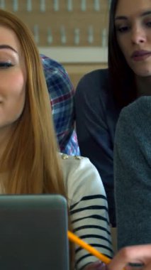 Canlı bir konferans salonunda, nişanlı bir erkek öğrenci kalemini bilgisayar ekranına tutkulu bir şekilde doğrulturken, düşünceli kızıl saçlı bir kız öğrenci sınıf arkadaşları arasında dikkatlice gözlemliyor. Bu canlı sahne işbirliğinin ruhunu özetliyor.