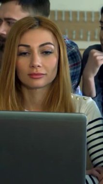 Neşeli sarışın bir kadın ve düşünceli sakallı bir adam da dahil olmak üzere çeşitli öğrencilerin bir araya geldiği canlı bir toplantı bir dizüstü bilgisayarın etrafında toplanarak, canlı fikirler ve anlayışlar alışverişinde bulundular. Enerjik üniversite salonu yaratıcılık ve yoldaşlık ile uğulduyor.