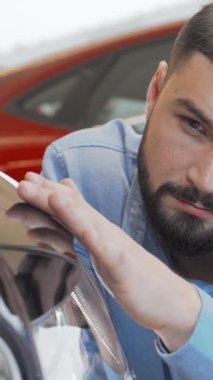 Şık sakallı kendine güvenen bir adam galeride yeni bir arabayı inceliyor. Heyecan ve cazibe saçıyor. Bu büyüleyici sahne, aracın modern tasarımı ve parlak bitişini gösteriyor. Potansiyel alıcıları deneyime davet ediyor.