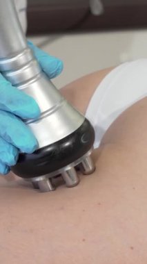 Kendini işine adamış bir güzellik uzmanı, zarif bir RF kaldırma cihazını kadın bir müşterinin uyluğunun üzerinden geçirir, deri dokusunu geliştirir ve genç bir ışıltıyı teşvik eder. Bu modern anti-selülit tedavisi şık bir güzellik kliniğinde ileri teknoloji ile birleştirildi.