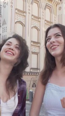 Neşeli iki genç kadın, mutluluk saçan, pitoresk bir caddede gezinen, şık alışveriş torbaları her adımda sallanan. Bu canlı sahne, arkadaşlığın ve maceranın ruhunu özetliyor. İçi dolu keyifli bir günü kucaklıyorlar.