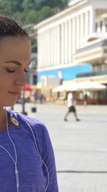 Parlak at kuyruklu odaklanmış genç bir kadın hareketli bir nehir yolunda saatini kontrol ediyor, enerjik havasını yükselten şık kulaklıklar takıyor. Bir aciliyet bakışı ile, bir sürat içine patlar, etkin bir şehir yaşam tarzının ruhunu somutlaştırır.