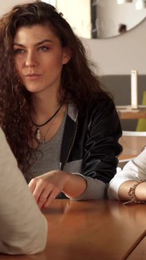 Şık bir şehir kafesinde, iki şık kız, canlı bir bağ sergileyerek, arkadaşlarının sözlerinden büyülenirler. Güzel Asyalı kadın kahvesinin tadını çıkarırken kıvırcık saçlı beyaz kız bu sıcacık yerde sıcaklığını ve bağlantısını yayıyor.