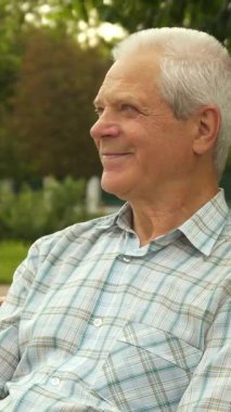 Güneşli bir parkta, sevimli küçük bir çocuk neşeyle büyükbabasının gözlerini kapatıyor, neşeli bir sürpriz ve kahkaha anı ateşliyor. Işıl ışıl gülümseyen beyaz çocuk, rahatça üzerine oturan yaşlı dedesinin arkasında duruyor.