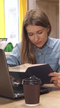 Canlı bir çalışma alanında, uzun kahverengi saçlı çekici genç bir kadın özenli erkek meslektaşı ile kitap hakkında görüşlerini paylaşıyor ve işbirliği içinde zengin bir atmosfer yaratıyor. Modern çalışma alanı parlak masalarla süslenir.