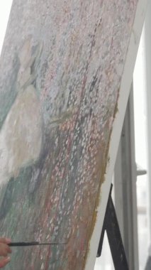 Güneşli bir atölyede, odaklanmış genç bir kadın büyük bir tuvale tutkuyla resim yaparken kendini canlı renklere boğuyor. Paleti elinde ve fırçasıyla yaratıcılığın ve sanatsal ifadenin özünü somutlaştırıyor.