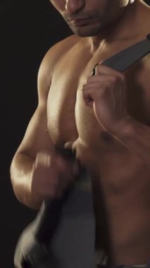 Yakışıklı, kaslı bir Afrikalı erkek müteahhidin çarpıcı bir görüntüsü iş elbisesini düzeltirken, heykel şeklindeki gövdesini parlak, siyah bir zemine karşı gözler önüne seriyor. Güçlü fiziği ve yoğun bakışları karşı konulmaz bir erkeklik karışımı yayıyor.