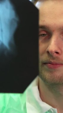 Kendini adamış genç bir dişçi, canlı yeşil bir klinik elbisesi içinde, hastaların karmaşık diş yapısını gösteren röntgen görüntüsünü titizlikle analiz ediyor. Parlak klinik ışık çene ve kesici dişlerin detaylarını vurgular, bir oluşturur