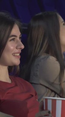 Canlı renklerle dolu sıcacık bir sinemada, iki çift yan yana oturur, tamamen sinematik deneyime dalarlar. Kırmızı gömlekli kız neşe saçıyor, gülüşü patlamış mısırın tadını çıkarırken sahneyi aydınlatıyor ve unutulmaz anılar yaratıyor.