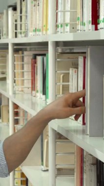 Şık sakallı neşeli, genç bir esmer adam akıllı telefonunu düzgün düzenlenmiş kitaplıklarla çevrili bir kaleydoskopla tutarken hevesle bir kitap arıyor. Onun ışıl ışıl gülümsemesi ve odaklanmış ifadesi bilgiye karşı derin bir tutkuyu yansıtır.