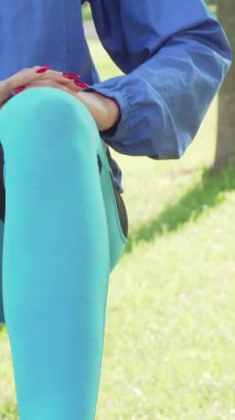 Göze çarpan mavi ceketli, odaklanmış atletik bir kadın, kulaklıklarını takmış, güneşli bir parkın ışıltılı yeşilliğinin ortasında enerjik sabah antrenmanına dalmaya hazır bir şekilde duruyor. Bereketli ortam motivasyonunu ve canlılığını arttırıyor.