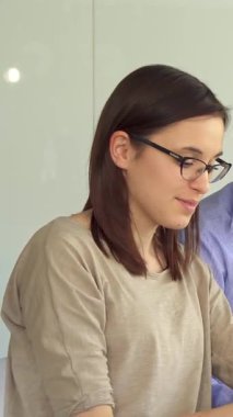 Canlı bir sahne, parlak, güneşli bir ofiste tutkuyla iş birliği yapan genç profesyonelleri yakalıyor. Mavi tişörtlü yakışıklı esmer bir adam dizüstü bilgisayarında odaklanmış kızıl bir kadınla görüşlerini paylaşırken, aynı zamanda çekici sakallı bir adam...