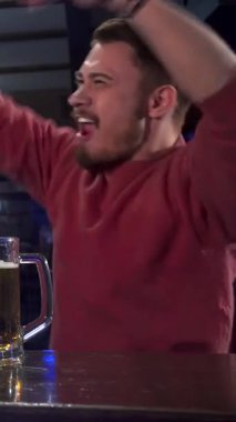 Coşkulu iki beyaz adam, mutluluk saçıyor, tezgahta sarılıyorlar, buzlu bira bardaklarını şen şakrak kaldırıyorlar. Bulaşıcı kahkahaları ve hareketli yoldaşlıkları havayı heyecanla doldurarak neşeli bir atmosfer yaratıyor.