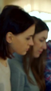 Hareketli genç bir kız öğrenci hareketli bir konferans salonunda kendinden emin bir şekilde ışıldıyor, çenesi düşünceli bir şekilde elinin üzerinde dinleniyor. Bu neşeli esmer, akademik coşku saçıyor. Nişanlı sınıf arkadaşları tarafından çevrelenmiş, davetkar bir atmosfer yaratıyor.