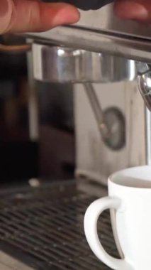 Yetenekli bir barista, odaklanmış bir kararlılıkla kahve makinesine, kusursuz beyaz bir fincana buharlı su dökerken rehberlik eder. Bu yakın çekim kahve yapımının karmaşık dansını vurgular, zengin aromaları yakalar ve...