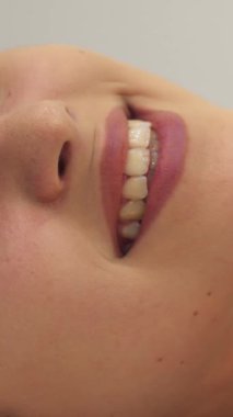 Hoş esmer bir kız masaj masasında yatarken yüzünü kameradan çeviriyor. Işıl ışıl gülüşü kaplıca atmosferini aydınlatıyor. Bu yakın plan, genç, beyaz bir kadının huzur verici güzelliğini yansıtıyor.