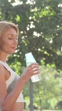 Işıl ışıl bir kadın neşe içinde su şişesinden yudumluyor, canlı bir parkın yemyeşil sularını süzen ılık güneş ışığını içine çekiyor. Bu canlı sahne sağlık ve canlılığı simgeliyor. Parlak gülüşünü ve canlandırıcı atmosferini gösteriyor.