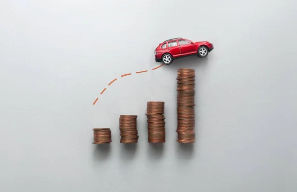 不断增加的燃料 价格概念 商业图表堆积如山的硬币 玩具车向上移动 图库图片