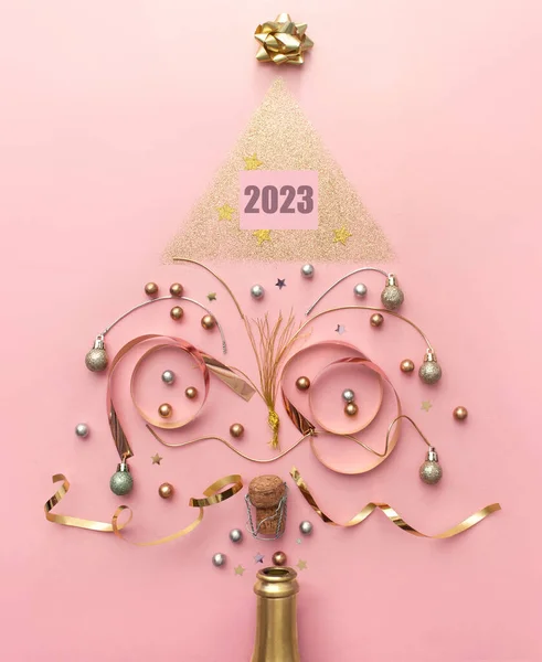 2023ゴールド装飾とシャンパンボトルから出てくる泡 クリスマスツリーの形 休日の新年のお祝いのコンセプトを作成します ロイヤリティフリーのストック画像