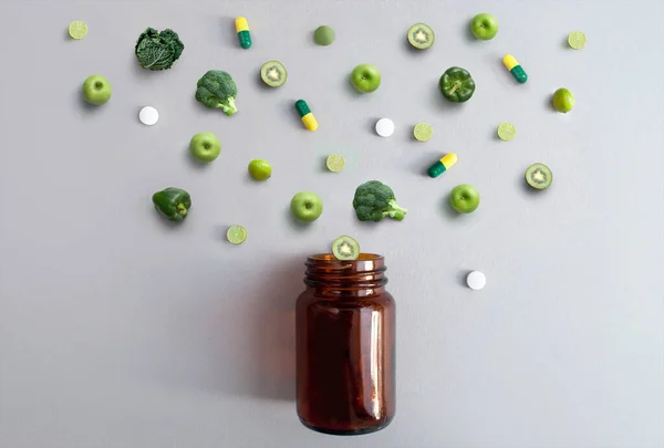 Green Vitamin Pills Capsules Alongside Apples Broccoli Cabbage Lime Kiwi — Stock Photo, Image