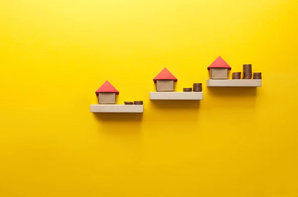 Grundstücksleiter Mit Miniatur Origami Haus Führt Steigenden Geldbeträgen lizenzfreie Stockfotos