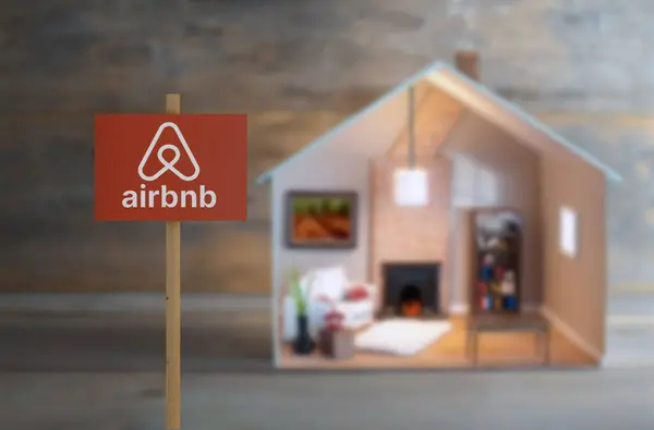 Cartel Airbnb Junto Una Casa Modelo Con Luces Encendidas Interior Imágenes de stock libres de derechos