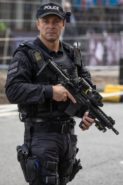 Windsor, İngiltere - 21 Ekim 2023: Silahlı bir polis memuru doğrudan kameraya bakıyor, elinde silah var.