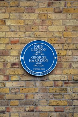 Londra, İngiltere - 4 Mart 2024: Londra 'da Baker Caddesi' nde, Apple Butik 'in nerede olduğunu gösteren plaket - ölen Beatles John Lennon ve George Harrison' ın isimleri plakette yer aldı..