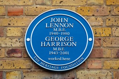 Londra, İngiltere - 4 Mart 2024: Londra 'da Baker Caddesi' nde, Apple Butik 'in nerede olduğunu gösteren plaket - ölen Beatles John Lennon ve George Harrison' ın isimleri plakette yer aldı..