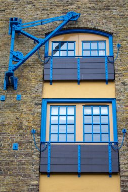 Exterior detail of the historic Millers Wharf, which is now a housing and apartment complex, located along the River Thames in London, UK. clipart