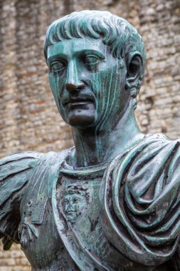 Londra, İngiltere - 3 Nisan 2024: Londra 'da arkasında Londra Duvarı kalıntıları olan Roma İmparatoru Trajan' ın heykeli. Duvarın o bölümü Romalılar tarafından yapıldı..