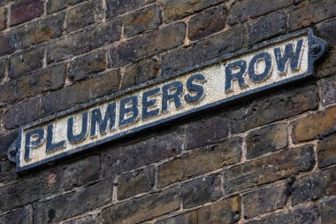 Londra, İngiltere 'deki Tower Hamlets bölgesinde Plumbers Row için bir sokak tabelasının yakın çekimi..
