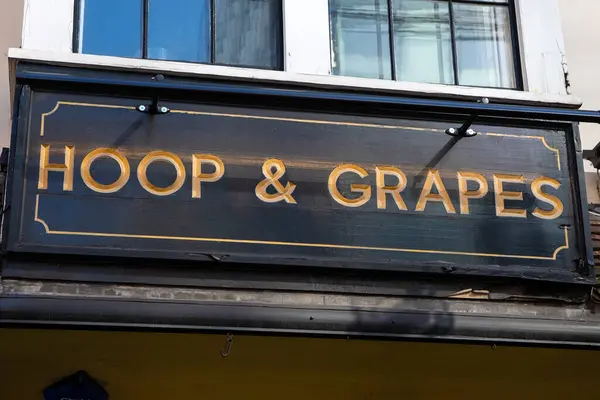 Stock image London, UK - March 2nd 2023: The sign above the entrance to the Hoop and Grapes public house - a Grade II listed building on Aldgate High Street in the City of London, UK.